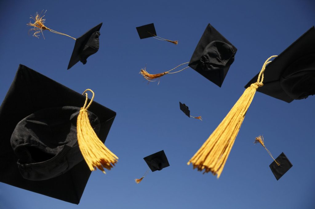 Graduation caps thrown in air
